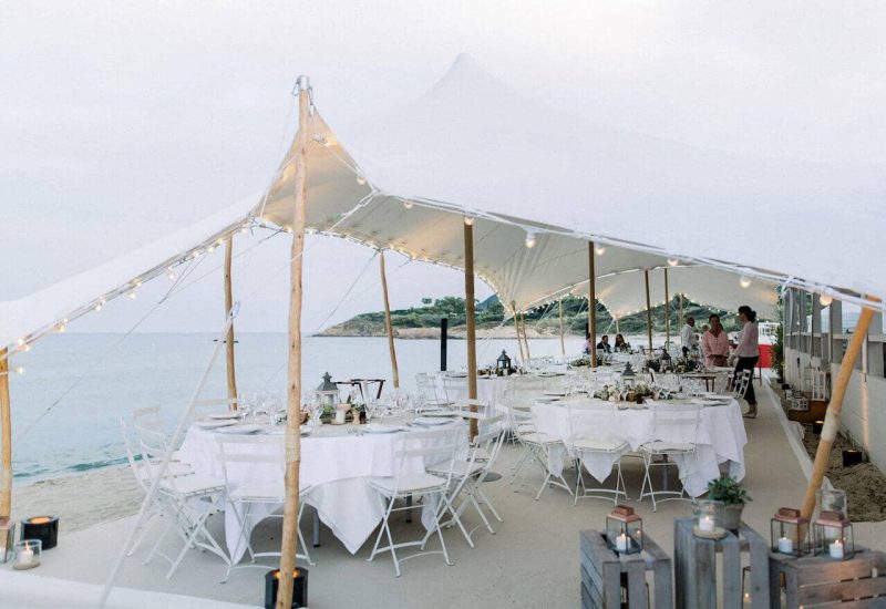 Une élégante réception de mariage en bord de mer, organisée par By Mademoiselle C, mettant en valeur un cadre romantique et sophistiqué. Ce lieu exceptionnel, avec sa tente blanche illuminée, crée l'atmosphère parfaite pour une célébration grandiose. Idéal pour un mariage sur mesure dans des destinations prisées comme la Provence, la Côte d'Azur et la Corse, cet événement unique incarne le luxe et le raffinement. Les tables soigneusement dressées, entour